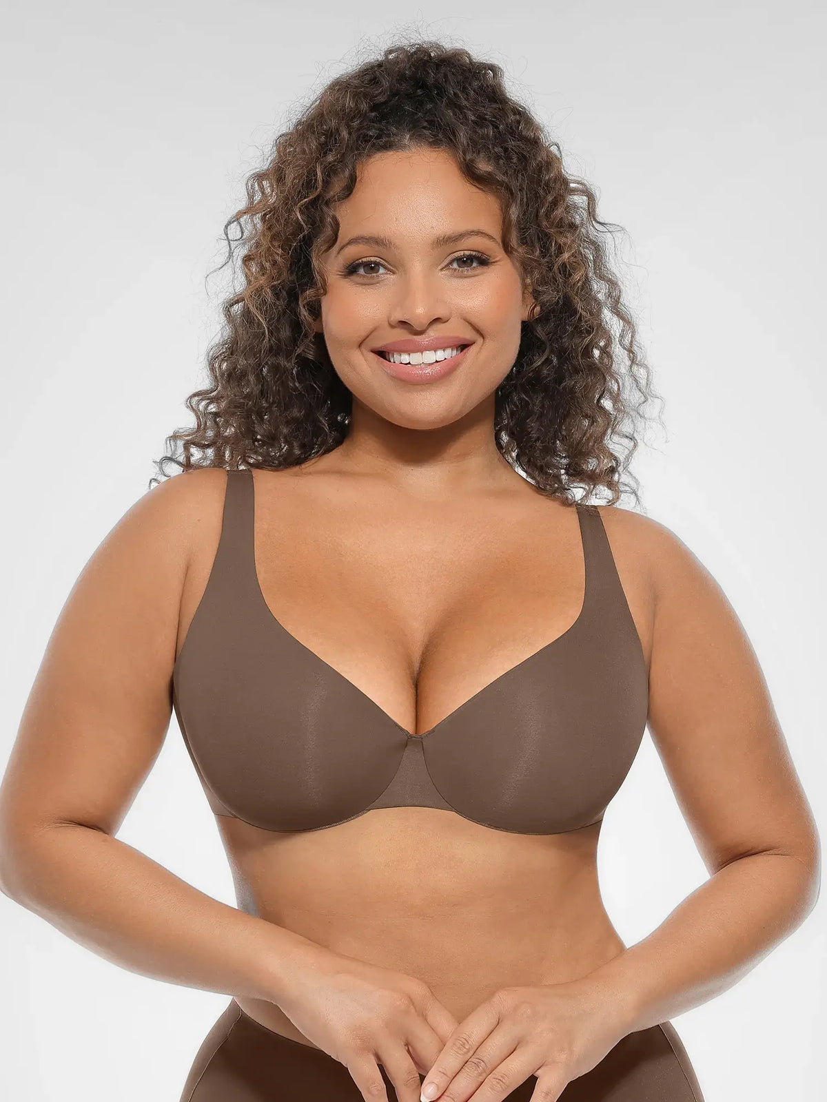 Front view of a model wearing a brown unlined deep V-neck underwire bra with hidden steel support and zero padding