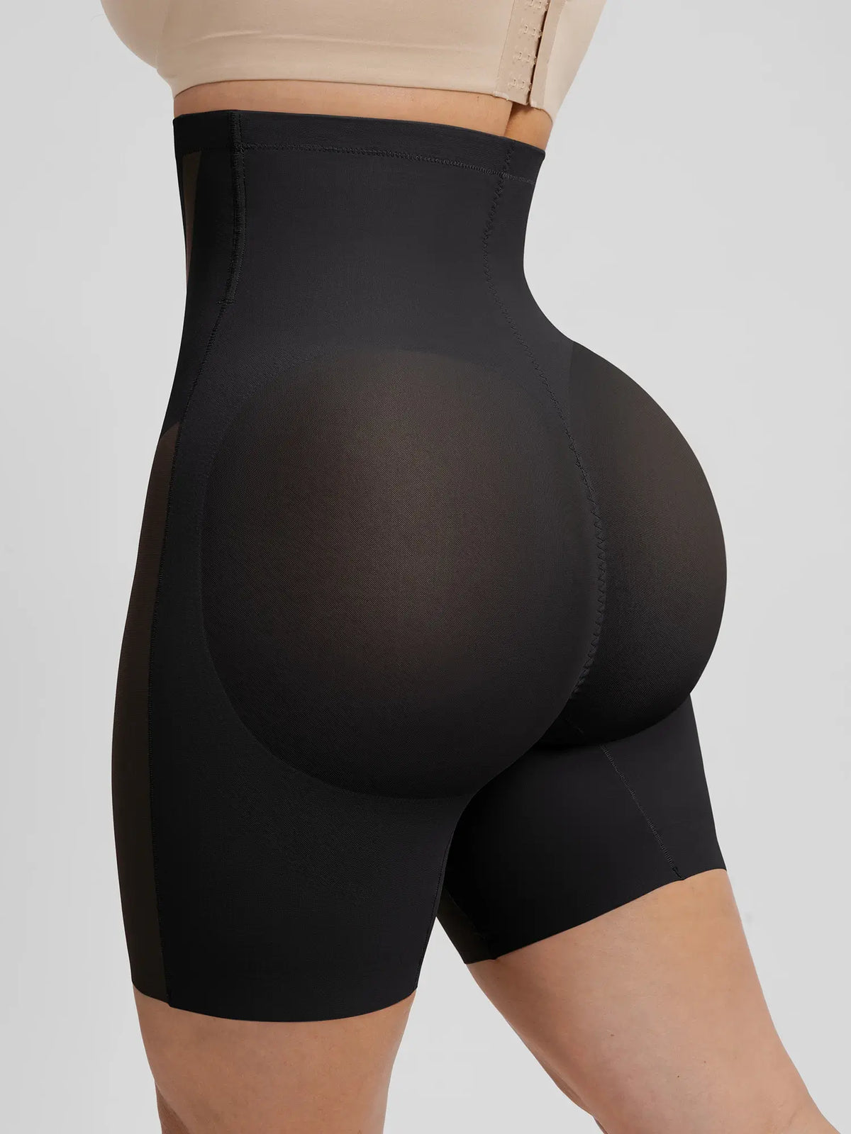 Side-rear view of black contouring shaper shorts showing the 3D peach buttock lift design to enhance natural curves