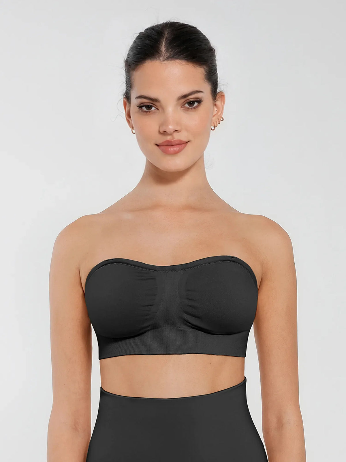 Front view of a model wearing a black seamless anti-slip bandeau bra featuring non-slip silicone grip and removable padding