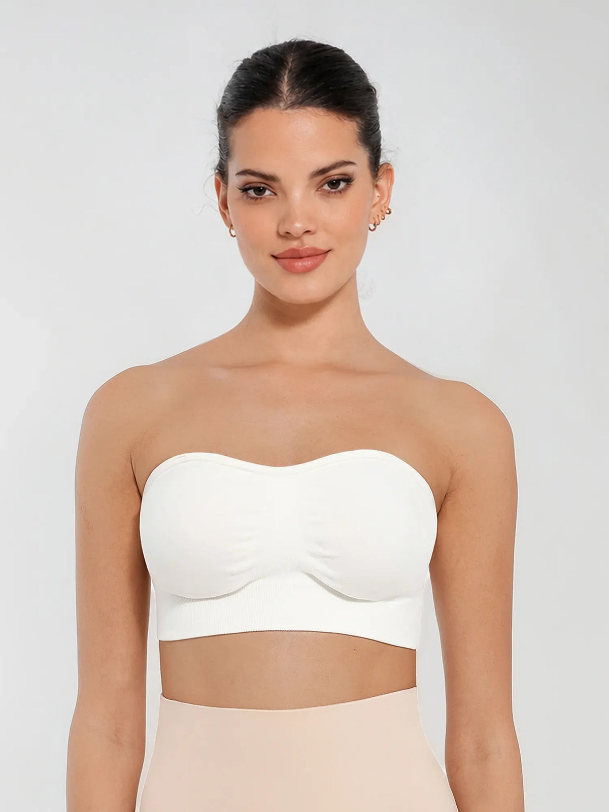 Front view of a model in a white seamless bandeau bra with gentle support and invisible second-skin comfort